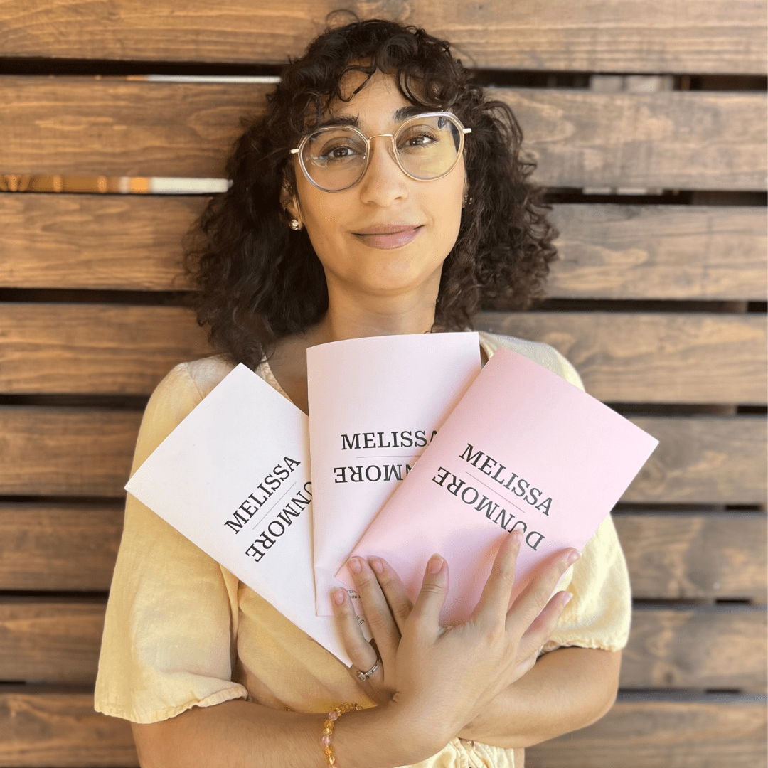 Melissa Dunmore holding 3 of her own poetry pieces.
