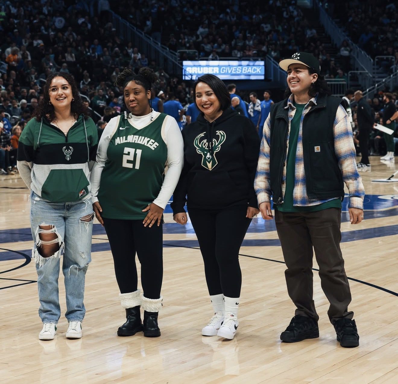 Public Allies Wisconsin staff members smiling together at a Milwaukee Bucks event